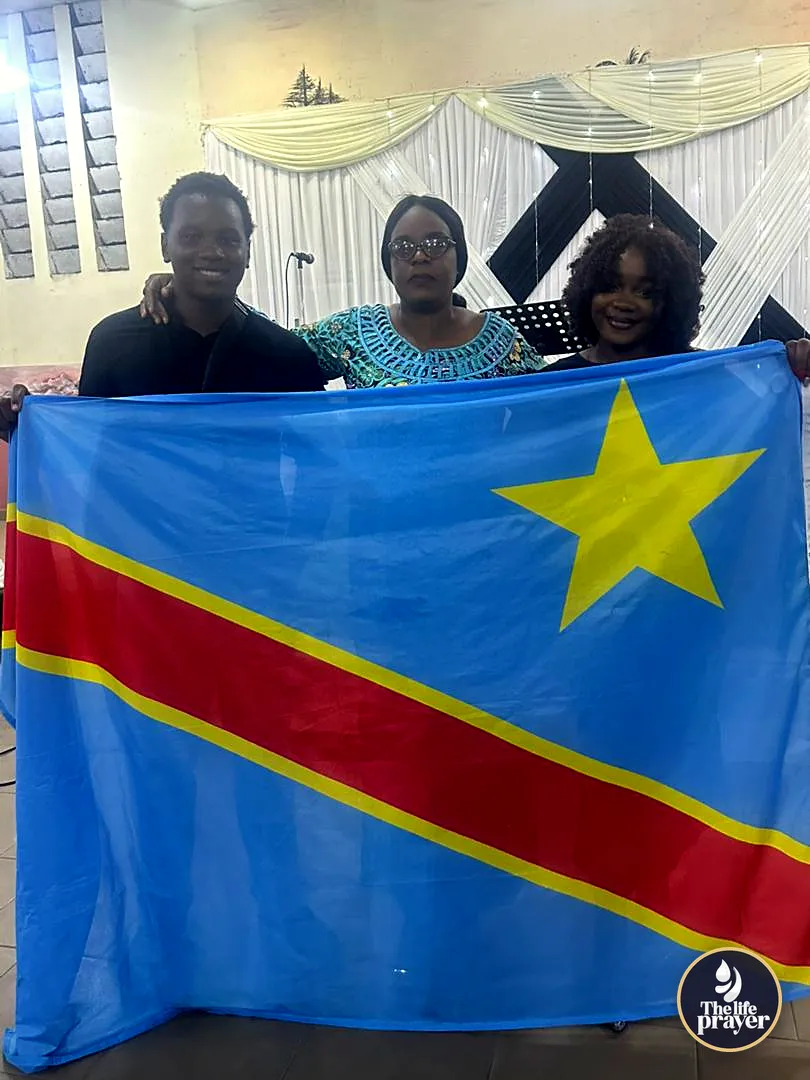 Trois participants tiennent le drapeau de la RDC