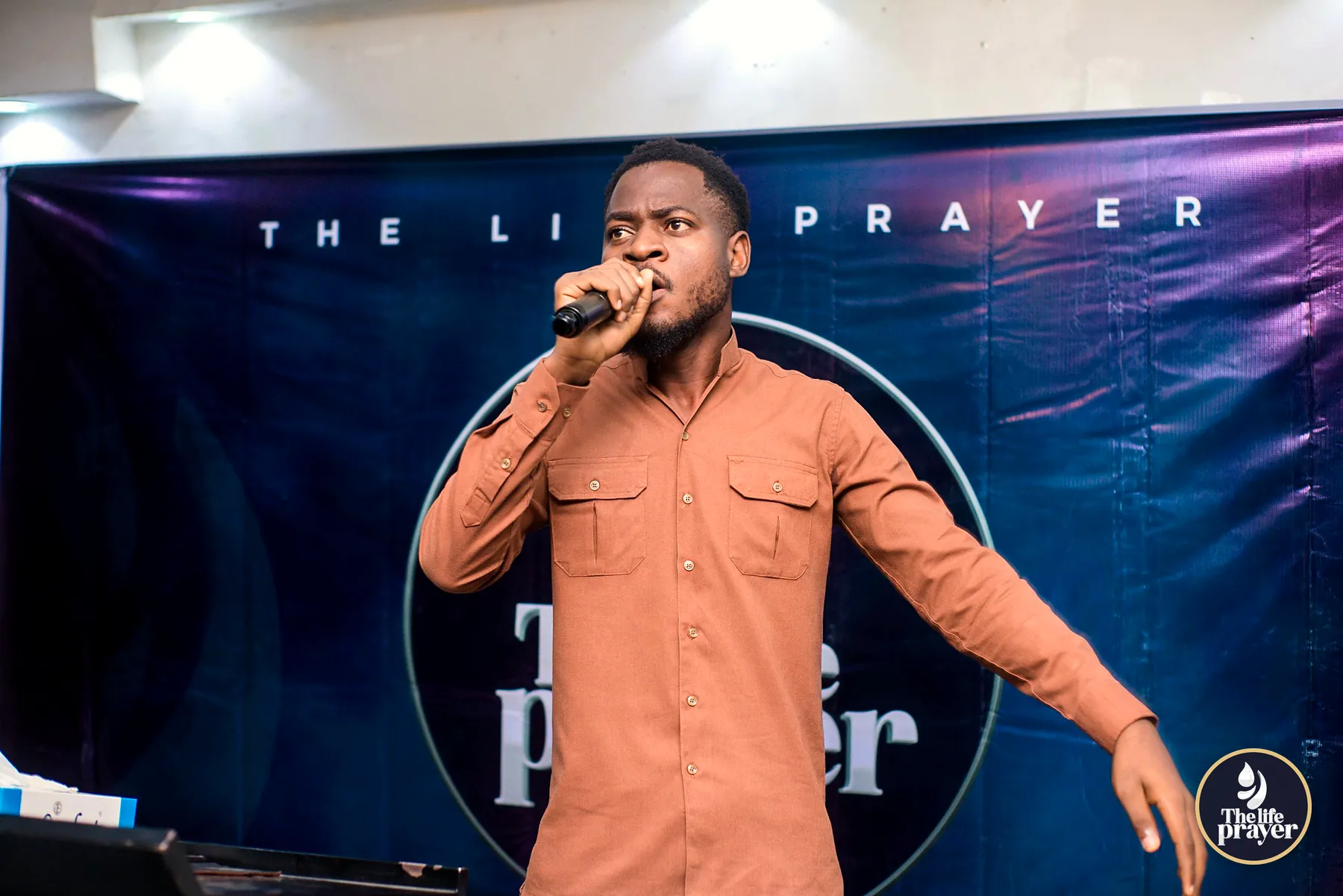 Un chantre devant le logo The Life Prayer